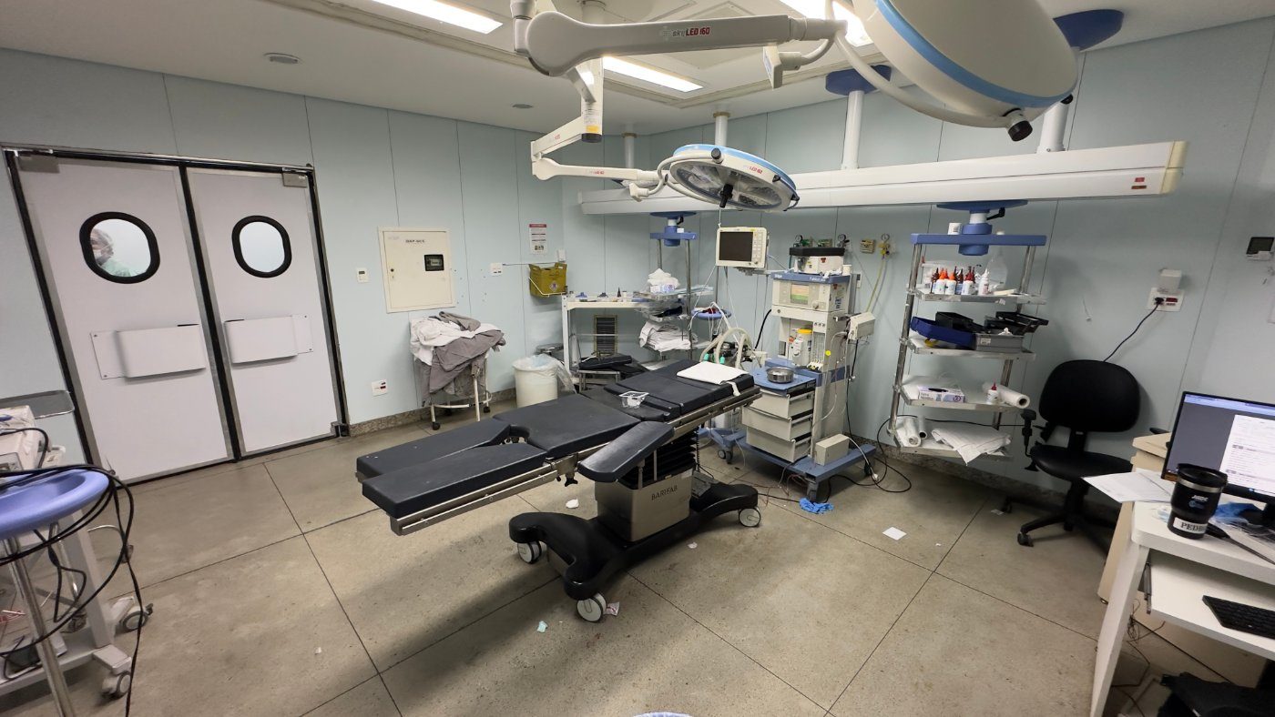 An operating room: table, lights, anaesthesia machine and double doors.